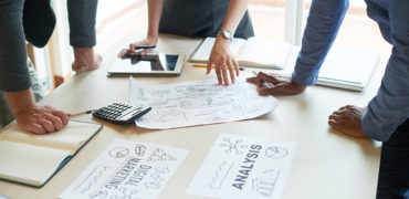 Close-up of businessman and woman discussing on stockmarket charts in office